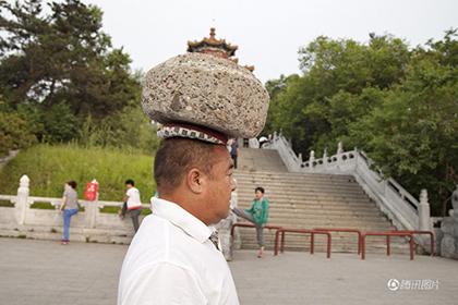 Китаец гулял с 40-килограммовым камнем на голове ради похудения