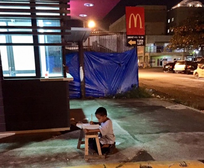 Этот малыш делал уроки прямо на улице при свете витрины! Всего одно фото перевернуло его жизнь